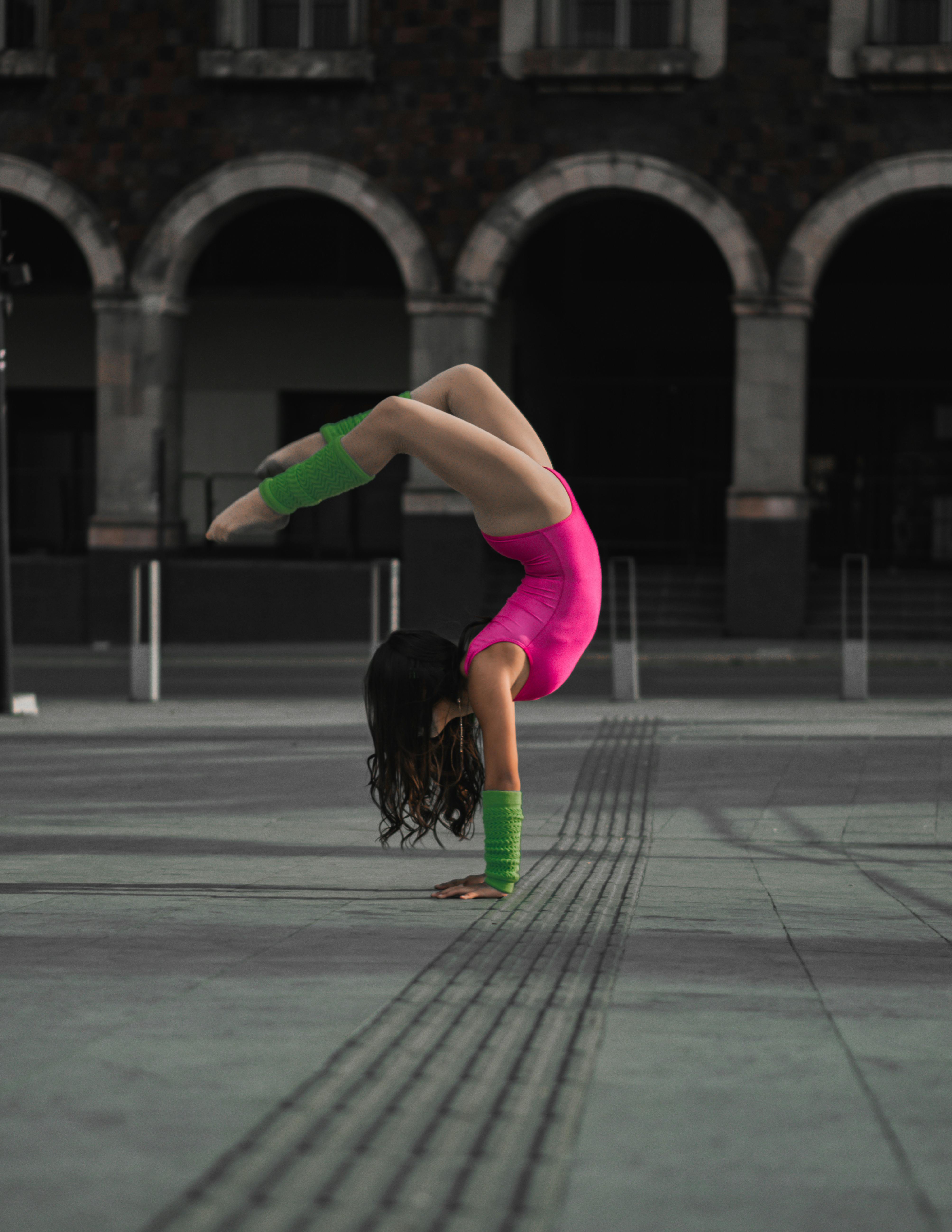 Femme sportive concentrée qui s’étire au sol dans une lumière naturelle, portant une tenue claire et respirante Haomah, symbole de confiance et de performance pendant les règles.